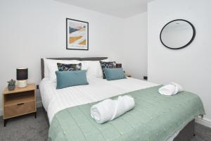 a bedroom with a large white bed with a mirror at Hanford Apartments in Stoke on Trent