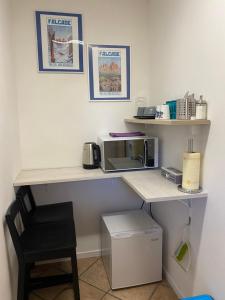 einen Schreibtisch mit einer Mikrowelle und einem Stuhl in einem Zimmer in der Unterkunft Al Tiglio Rooms in La Valle