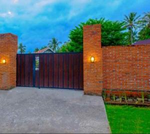 a red brick fence with a gate and a fence at Tiffany Garden in Mangsit