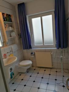 a bathroom with a toilet and a sink and a window at Ferienwohnung Andresen in Rerik +8 photos
