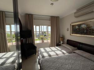 1 dormitorio con 1 cama, 1 silla y ventanas en Hotel Paraíso Del Mar, en Nerja