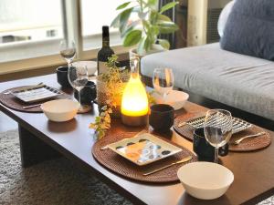 a coffee table with wine glasses and dishes on it at サンコート南6条壱番館 in Sapporo