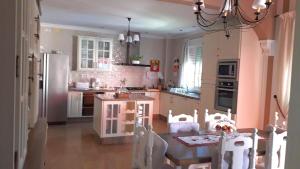 una cucina con tavolo, sedie e tavolo e una cucina con frigorifero di LOS CLAVELES a Hornachuelos