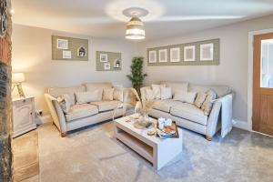 a living room with two couches and a coffee table at Host & Stay - Sion Hall Cottage in Alnwick