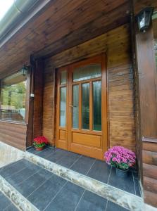 una puerta de madera delantera de una casa con dos macetas en Hámori Álom, en Miskolc