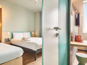 um quarto de hotel com uma cama e uma cama e um quarto em ibis budget Nancy Laxou em Nancy