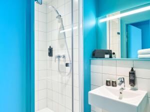 a bathroom with a white sink and a shower at ibis budget Nancy Laxou in Nancy