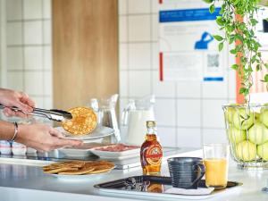 uma pessoa está a preparar comida num balcão da cozinha em ibis budget Nancy Laxou em Nancy