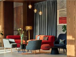 a living room with a red couch and chairs at Hotel Bergo Resort & SPA in Szklarska Poręba