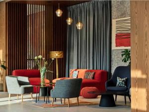 salon z czerwoną kanapą i krzesłami w obiekcie Hotel Bergo Resort & SPA w Szklarskiej Porębie