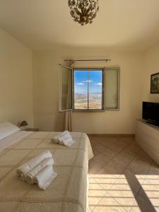 Schlafzimmer mit einem Bett, einem Fenster und einem TV in der Unterkunft Belvedere in Santa Margherita di Belice