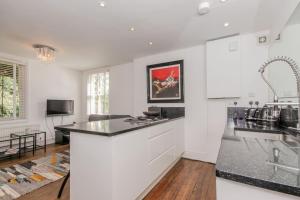 a kitchen with white cabinets and a black counter top at Flat 2, 158 Abingdon Road in Oxford