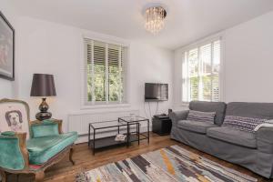 uma sala de estar com um sofá e uma cadeira em Flat 2, 158 Abingdon Road em Oxford