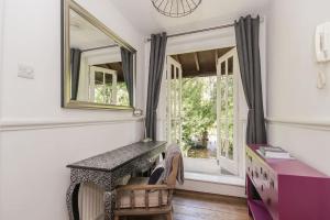 Zimmer mit einem Tisch, einem Spiegel und einem Fenster in der Unterkunft Flat 2, 158 Abingdon Road in Oxford