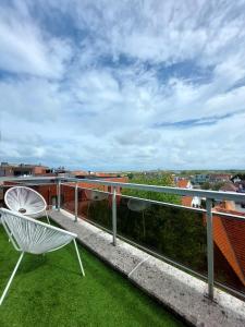 a white chair on a balcony with a view at Penthouse VI in Koksijde