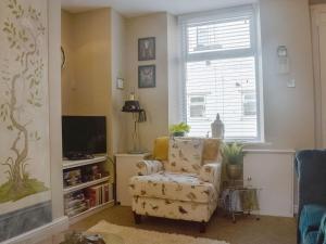 a living room with a chair and a window at Church Mouse Cottage in Clitheroe