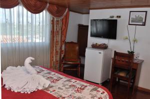 a bedroom with a white swan on a bed at Hotel Suite Imperial in Tunja