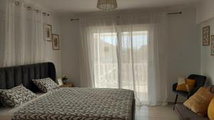 ein Schlafzimmer mit einem Bett und einem großen Fenster in der Unterkunft Nissi Golden Sands Sunny Apartment A1D4 in Ayia Napa