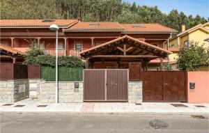 ein Haus mit einem Holztor und einem Zaun in der Unterkunft Cozy Home In Ribadesella With Wifi in Ribadesella