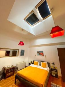 Un dormitorio con una cama amarilla y algunas ventanas en The Only One Apartments, en Niš