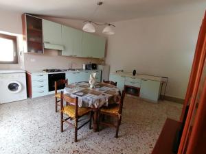 a kitchen with a table and chairs and a kitchen with a stove at Al Belvedere in Isnello