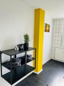 um quarto com uma prateleira preta e uma parede amarela em Shadow Sleep em Schonungen