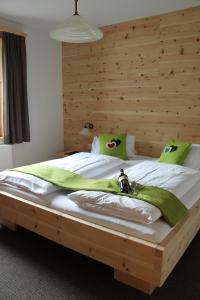 a bedroom with a large bed with a wooden headboard at Landhaus Lenauer in Lermoos