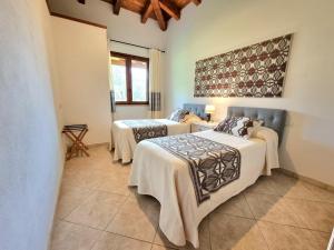 een kamer met drie bedden met dekens erop bij Saludi&Trigu - Rural Apartments in Iglesias