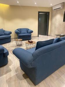 un soggiorno con 2 divani blu e 2 tavoli di فندق المنصور a Aḑ Ḑabbīyāt al Janūbīyāt Altre 17 foto