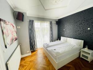 a bedroom with a bed with a black wall at aday - Aalborg City Center big apartment in Aalborg