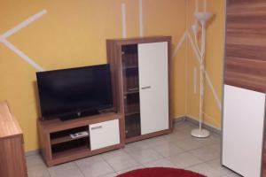 a living room with a tv and a entertainment center at Am Tor des Steigerwaldes in Gerolzhofen