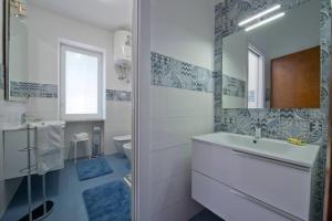 a white bathroom with a sink and a mirror at AMORE RENTALS - Villa Isabel in Praiano +37 photos