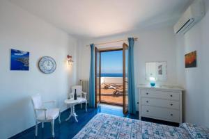 a bedroom with a bed and a door to a balcony at AMORE RENTALS - Villa Isabel in Praiano