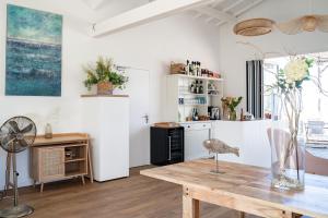 een keuken met witte muren en een houten tafel bij Camping Le Bellevue in La Tranche-sur-Mer