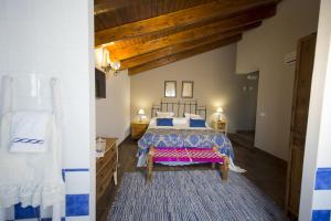 um quarto com uma cama grande com lençóis azuis e brancos em Casa Rural Valle de la Laguna em Valdelaguna
