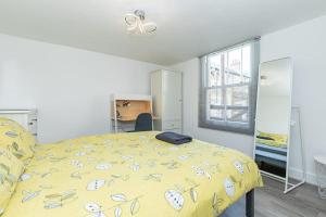 a bedroom with a yellow bed with a yellow comforter at Flat 3, 158 Abingdon Road in Oxford