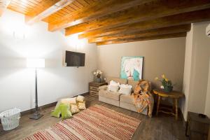 ein Wohnzimmer mit einem Sofa und einem TV in der Unterkunft Casa Rural Valle de la Laguna in Valdelaguna