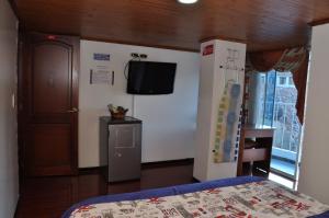 a bedroom with a bed and a tv on a wall at Hotel Suite Imperial in Tunja