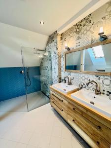 uma casa de banho com 2 lavatórios e um chuveiro em Lilac House - holiday and relaxation house em Ohrobec