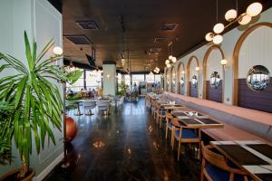 a restaurant with tables and chairs and a plant at Grand Hotel Victory in Aktau