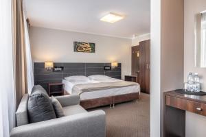 a hotel room with a bed and a couch at Hotel Leśny in Białystok