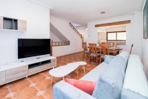 a living room with a couch and a tv at Espanatour PLAYA FLAMENCA in Orihuela Costa