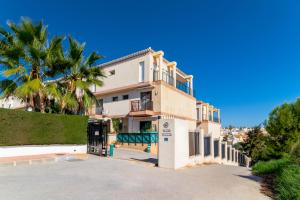 a building with a palm tree in front of it at Espanatour PLAYA FLAMENCA in Orihuela Costa