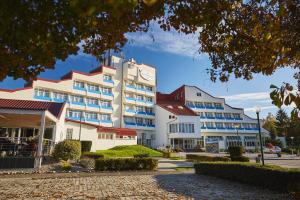 ein großes weißes Gebäude mit einer Uhr drauf in der Unterkunft Thermal Resort Hotel Lendava in Lendava