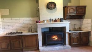 a kitchen with a fireplace and a stove at Swallows, Beautiful gite in the grounds of Chateau Beauvoir 