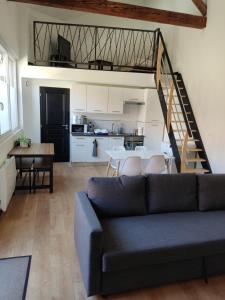 a living room with a couch and a kitchen at Résidence du Lavoir in Saint-Étienne-de-Saint-Geoirs