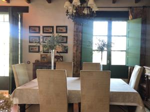 comedor con mesa blanca y sillas en El Encinar, Country House in Alanís, Andalusia en El Encinar