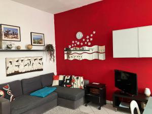 - un salon avec un canapé et un mur rouge dans l'établissement Appartamento incantevole a Parma, à Parme