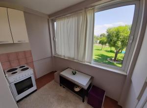a small kitchen with a stove and a window at Apartment Helena Airport in Podgorica