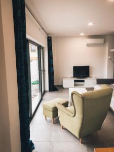 a living room with a couch and a chair and a television at Quinta do Fojo Valonguinho, Barrô in Barrô